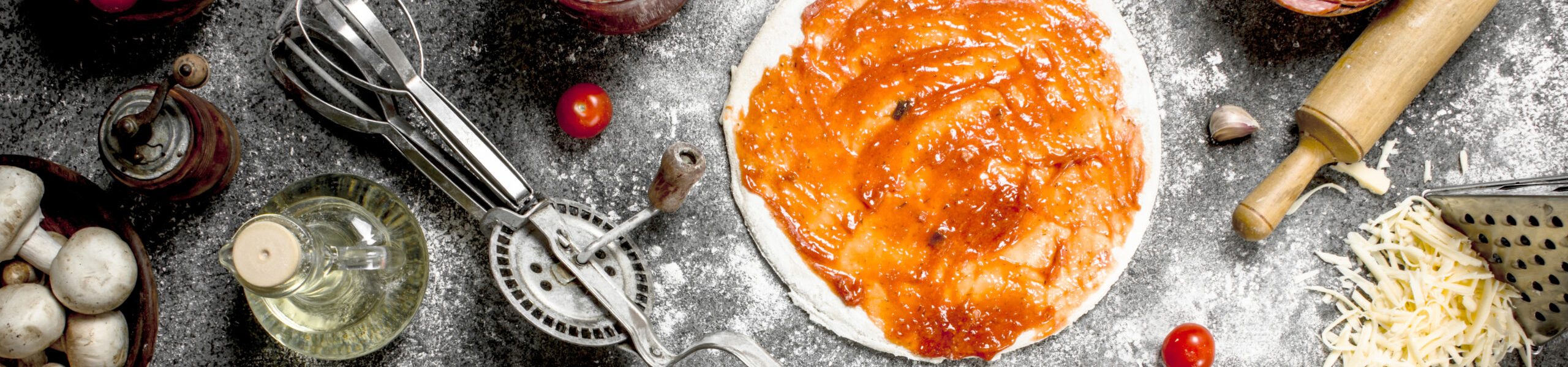 Preparation of pizza. On a rustic background.